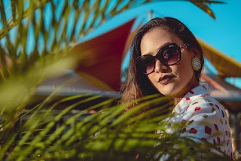 Woman in White and Red Shirt Behind Green Plant