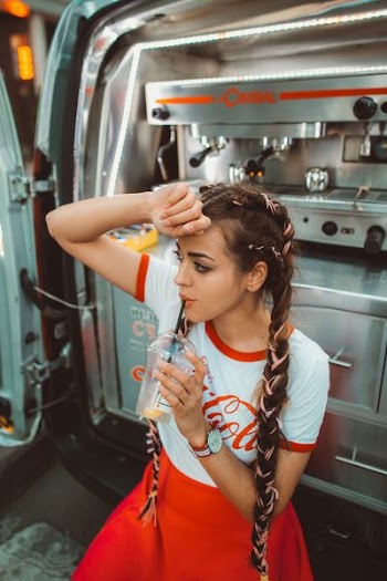 woman in white and red shirt holding disposable cup