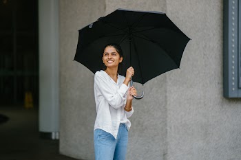Woman in White Button-up Long-sleeved Shirt Holding Black Umbrella