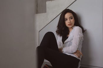 Woman in White Button-up Shirt Sitting Against Wall