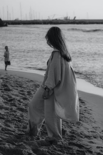 Woman in White Coat Walking on Beach · Free Stock Photo