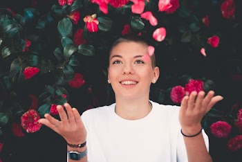 Woman in White Crew-neck Shirt Playing Pink Flowers