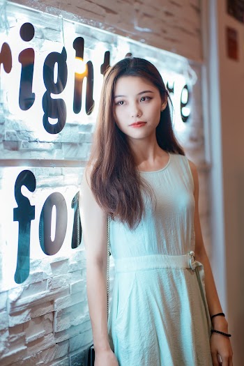 Woman in White Crew-neck Sleeveless Dress Standing Indoors