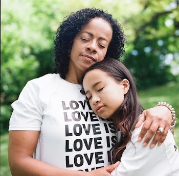 Woman in White Crew-neck T-shirt Hugging Woman Shallow Focus Photography