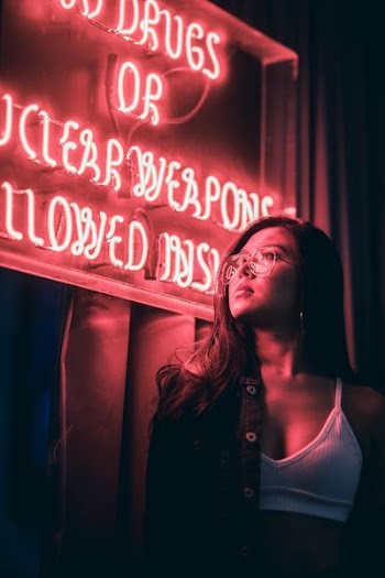 woman in white crop top near red neon-light signage low-light photography