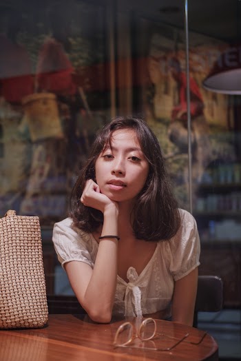 Woman in White Crop Top Sitting on Chair