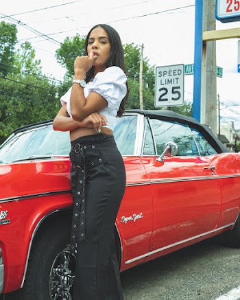 Woman in White Crop Top Standing Beside Red Coupe