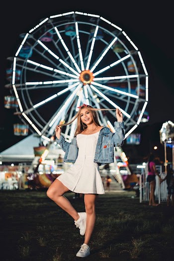 Woman in White Dress and Blue Denim Jacket Standing in Front of Ferris Wheel