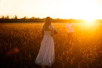 Woman In White Dress Holding Bouquet on Field 