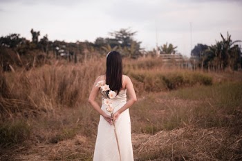 Woman in White Dress Holding Flowers
