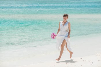 Woman in white dress running on the beach