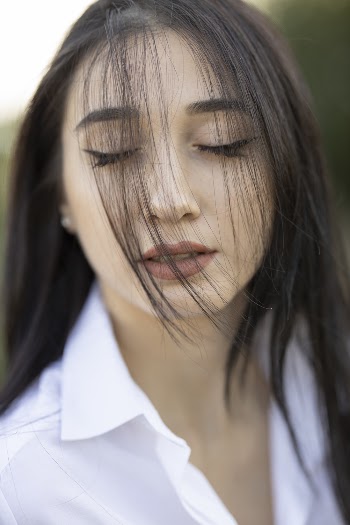 Woman in White Dress Shirt Closing Her Eyes