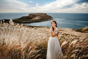 Woman in White Dress Standing in the middle of a Grass Field