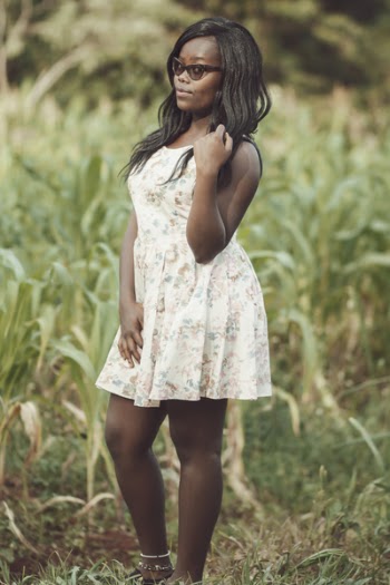 Woman in White Floral Minidress Standing on Grass