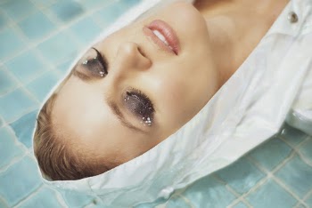 Woman in White Hooded Outfit Lying on Water