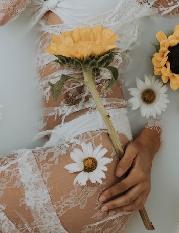 woman in white lace lingerie holding sunflower