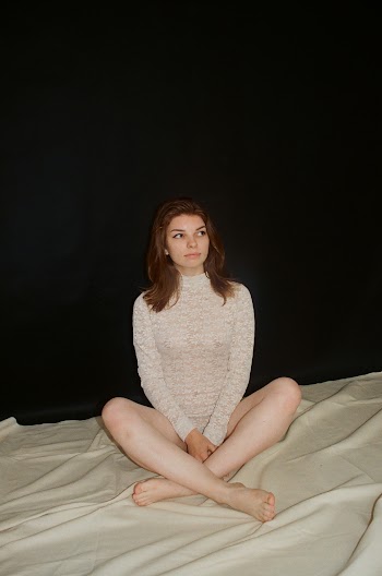 Woman in White Lace One-piece Bodysuit Sitting on White Textile