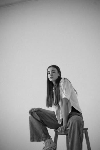 Woman in White Long Sleeve Shirt and Black Pants Sitting on Chair · Free Stock Photo