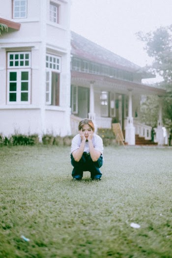 Woman in White Long Sleeve Shirt and Blue Denim Jeans Sitting on Green Grass Field during · Free Stock Photo