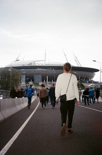 Woman in White Long-sleeve Top Walking to Stadium