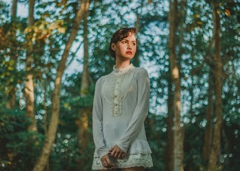 Woman in White Long Sleeved Mini Dress Standing Under Trees