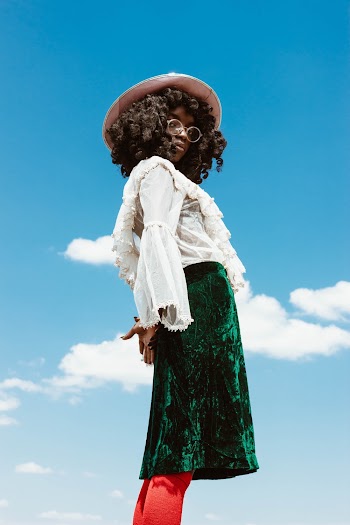 Woman in White Long-sleeved Top and Green Skirt Standing Outdoors