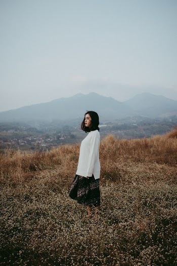 Woman in White Long-sleeved Top and Skirt Standing on Field