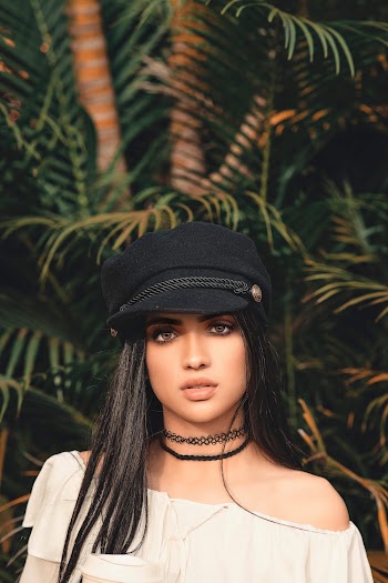 Woman In White Off-shoulder Shirt And Black Cap 