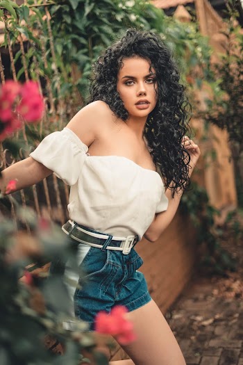Woman in White Off-shoulder Shirt and Blue Denim Shorts