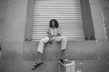 Woman in White Pants and Pair of Black Nike Benassi Slides