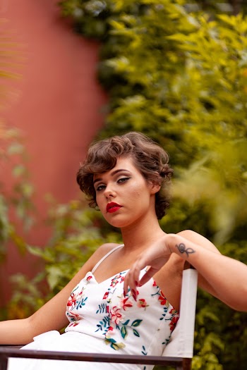 Woman in White,red,and Green Floral Top Sitting on Chair