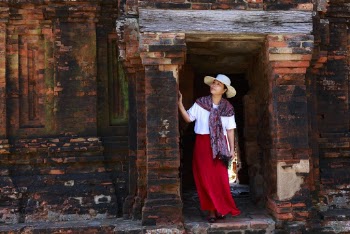Woman in White Shirt and Red Skirt Standing on Doorway