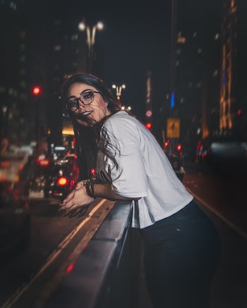 Woman in white shirt posing outdoor during night time
