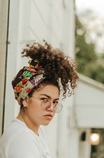 Woman in White Shirt Wearing Headdress Looking Directly on Camera