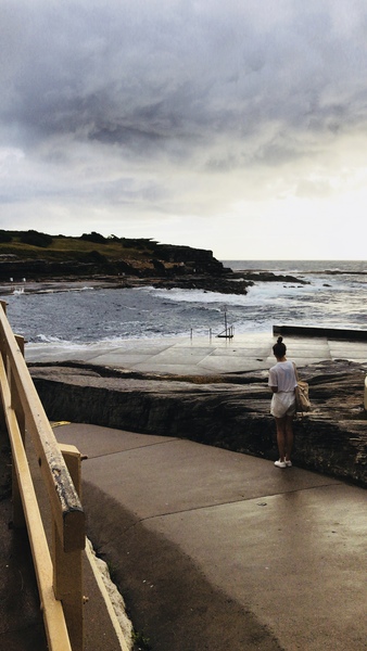 Woman in White Shorts Standing Near Large Body of Water