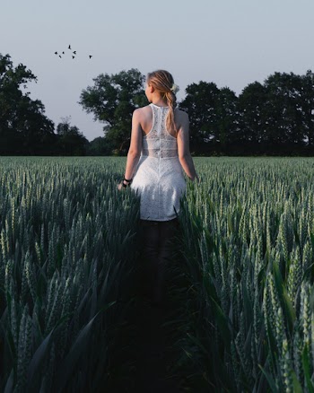 Woman in White Sleeveless Dress Near Green Plants