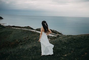 Woman In White Sleeveless Dress Overlooking The Sea