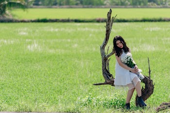 Woman in White Sleeveless Dress Sitting on Tree
