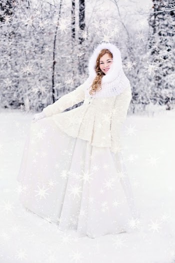 Woman in White Snow Suit Standing on a Snow Covered Ground Behind a Snow Covered Tree
