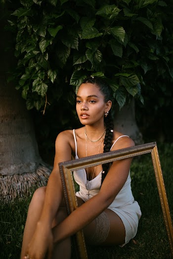 Woman in White Spaghetti Strap Dress Sitting on Grass