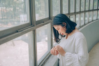 Woman in White Sweater in Front of Window
