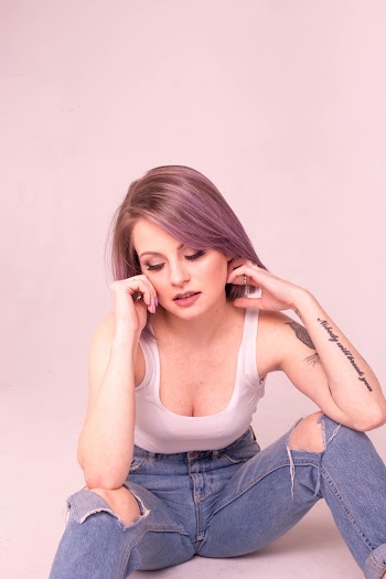 Woman In White Tank Top And Blue Denim Jeans Sitting