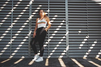 woman in white tank top leaning on wall