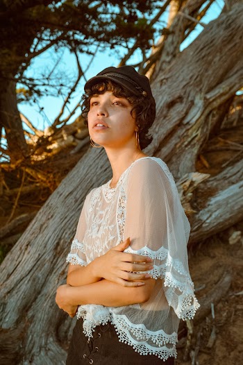 Woman In White Top Beside Driftwood