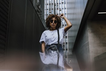 Woman in White Top by Concrete Wall