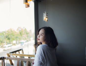 Woman in White Top Looking Outside Window