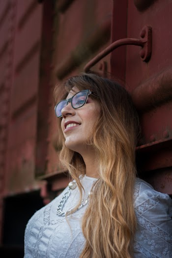 Woman in White Top Wearing Silver-colored Chain Necklace Leaning on Train