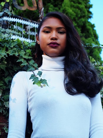 Woman in White Turtle Neck Sweater Beside Bush