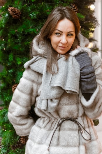 Woman in Winter Coat Standing Near Christmas Tree