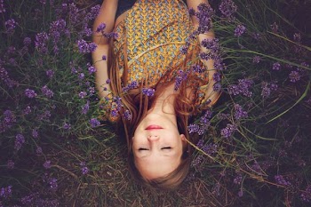 woman in yellow and teal top sleeping beside lavenders